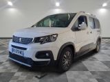 la camionnette blanche est garée sur le sol en damier d'un garage