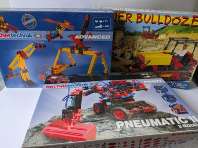 trois boîtes de legos de différents jeux de construction sur une table