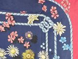 une photo d'une nappe bleue et rose ornée de fleurs