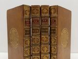 trois livres sont empilés sur une surface blanche