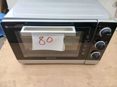un four grille-pain posé sur une table, avec un mot collé dessus