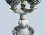 a white and blue bowl and two bowls on a stand