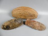 three rocks and a piece of bread on a table