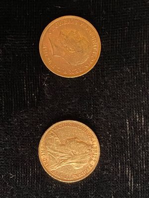 deux pièces d'or posées côte à côte sur une surface noire