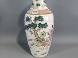 a white vase with a painting on it sitting on a table