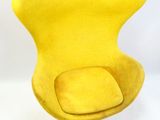 une image représentant une chaise jaune posée sur un sol blanc