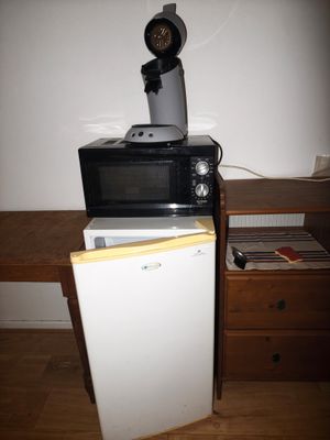 a microwave sitting on top of a refrigerator in a room