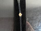 wrist watch in a velvet case on a table with a person taking a picture