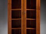 une grande bibliothèque en bois avec des portes vitrées et des étagères