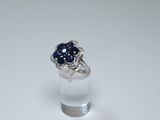 an image of a ring with a blue sapphire and diamonds on it