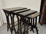 trois tables gigognes noires placées les unes à côté des autres sur un sol en béton