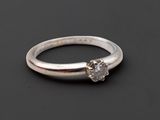 gros plan d'une bague en diamant sur une surface noire