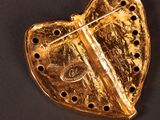 a gold heart shaped object on a black surface