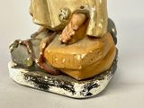a figurine of a man sitting on a rock