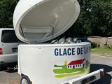 a small ice cream cart with a large ice cream container on the back