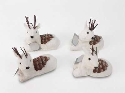 trois cerfs blancs aux bois bruns sont couchés sur une surface blanche