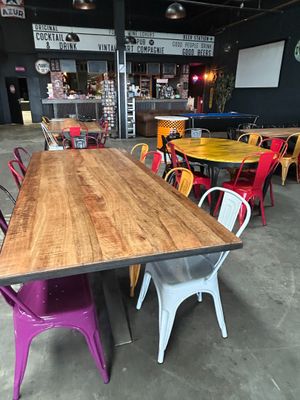 tables and chairs in a room with a clock on the wall