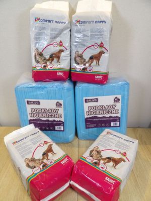 four bags of dog food sitting on top of a wooden table