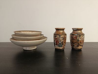 three vases and a bowl sitting on a table