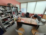 a room with a desk, chairs, and a computer on it