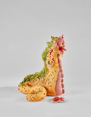 figurine représentant un dragon jaune et vert assis sur une surface blanche