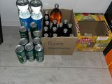bottles of soda and cans of soda sit on the floor next to a box of soda