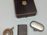 une petite boîte en métal avec une pochette et un porte-clés à côté