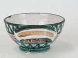 a green and white bowl sitting on a white surface