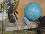 une vitrine en verre contenant une boule bleue et un appareil photo