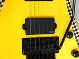 a yellow guitar with a black and white checkered design on it