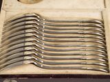 six spoons in a case that are sitting on a table