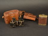 a brown bag and a pair of binoculars on a black background