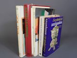 plusieurs livres sont empilés sur une surface grise