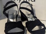 Les sandales noires de la femme sont posées sur une table blanche, à côté d'une boîte