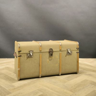 two trunks sitting on a wooden floor with a gray background
