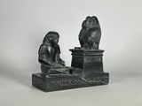 statue d'une femme assise sur un socle, avec un oiseau sur la tête