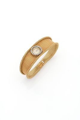 a close up of a gold bracelet on a white background