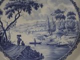 a blue and white plate with a painting on it