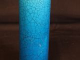 un gros plan d'un vase bleu sur un fond marron