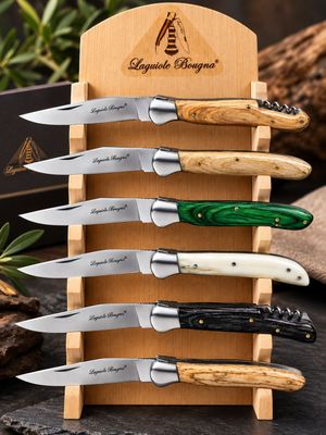 five knives in a wooden holder on a table