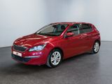 the red car is parked in a large room with white walls