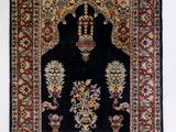a black and red rug hanging on a wall