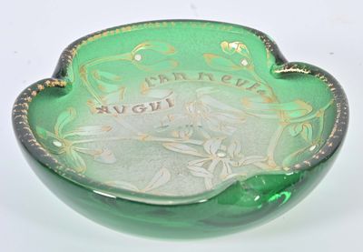 a green glass bowl with a gold decoration on it