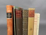 Plusieurs vieux livres sont empilés les uns sur les autres sur une surface grise