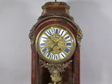 a clock that is sitting on a table with a statue on top of it
