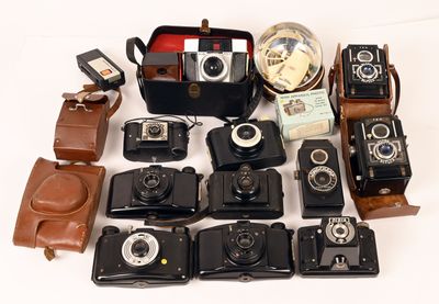 a lot of old cameras and a case on the table