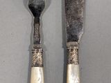 two forks, a knife and a spoon sitting on a table