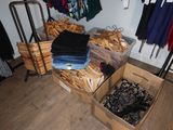 boxes of clothes are stacked on a wooden floor in a closet