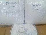 trois rouleaux de papier toilette emballés dans des sacs en plastique, posés sur une boîte en carton