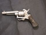 an old revolver with a wooden handle on a black cloth